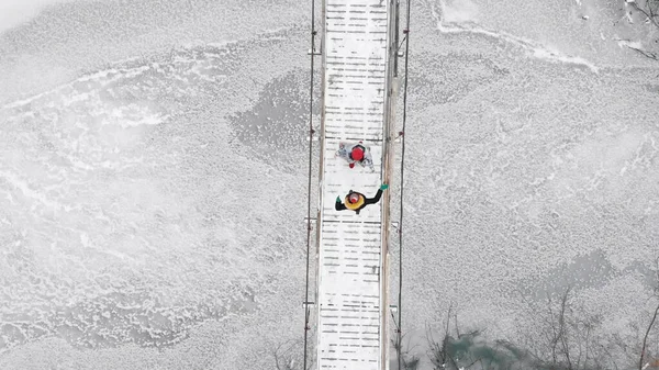 Dos amigas coloridas caminando una hacia la otra en el puente nevado — Foto de Stock