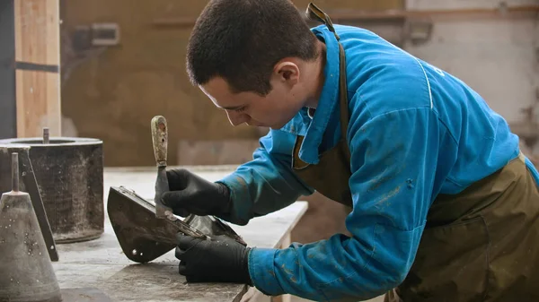 Industria del calcestruzzo - il lavoratore pulisce il modulo per la colata del calcestruzzo dagli avanzi — Foto Stock