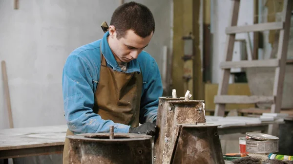 Industria del calcestruzzo - giovane che lavora con dettagli concreti in officina - aggiungendo viti ad esso — Foto Stock