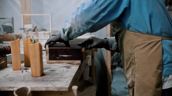 Concrete industry - worker preparing glass and silicone for the working on the souvenir statue - putting it in wooden separation compartment — ストック写真