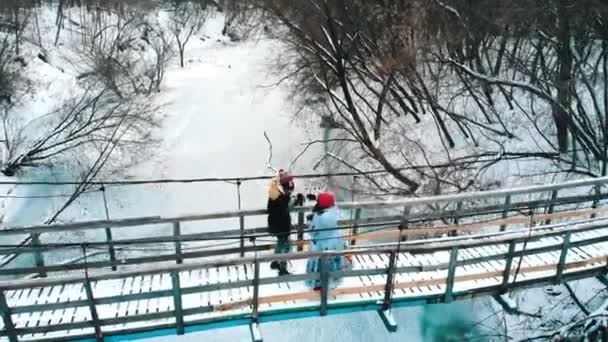 Dos amigas jóvenes tomando bebidas calientes del termo en el puente — Vídeo de stock