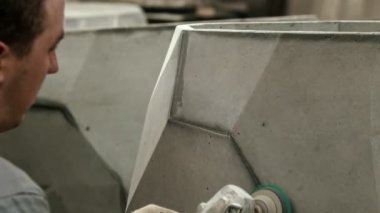 Concrete industry - man worker polishing an object indoors
