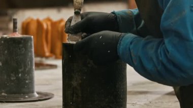 Beton endüstrisi. Formu temizlemek için keskiyle çalışan bir adam.