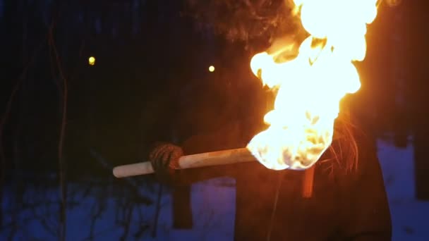 A woman waving with torch standing in winter forest — Stockvideo