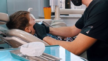 Modern dişçilikte dişlerini yaptıran küçük bir çocuk.