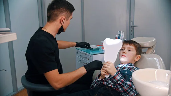 A little boy having a treatment in the modern dentistry - the boy looking in the mirror — Stock Photo, Image