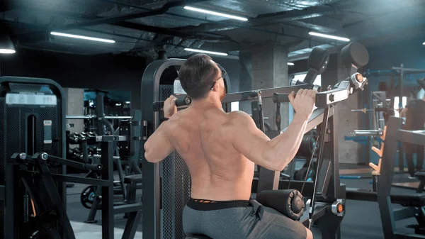 Vücut geliştiren bir adam spor salonunda güç egzersizleri yapıyor. — Stok fotoğraf