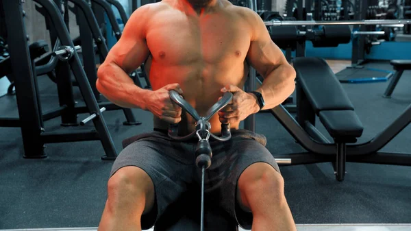 一位有魅力的健美运动员在体育馆里做力量锻炼- -用手在霓虹灯下拉动身体重量 — 图库照片