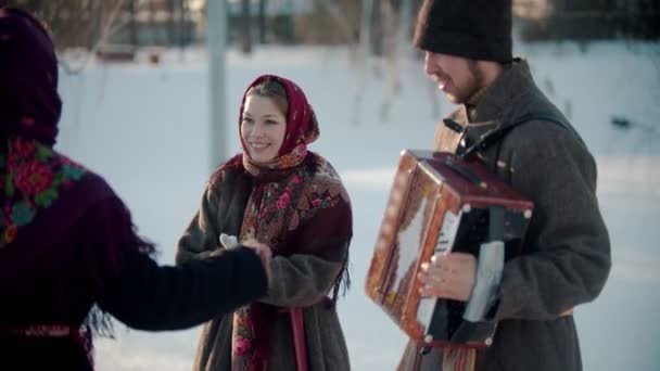 Russische Traditionen - eine schöne Frau in traditioneller Kleidung tanzt fröhlich zur Musik des Akkordeons — Stockvideo