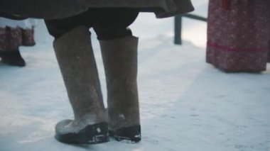 Rus gelenekleri - çizmeli bir adam ve koyun postlu bir ceket karda dans ediyor