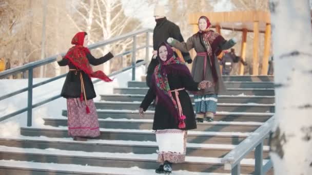 Folclore russo - mulheres alegres e homens estão dançando dança russa no parque nas escadas — Vídeo de Stock