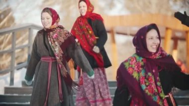 Rus folkloru. Adam, gülümseyen ve gülen eşarplı kadınları alkışlıyor.