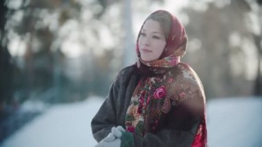 Rus folkloru. Eşarplı güzel Rus kadın ellerini çırpıyor ve gülümsüyor.