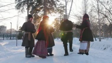 Rus halkı - geleneksel kostümlü bir grup insan bir çember içinde dans edip alkışlıyorlar.