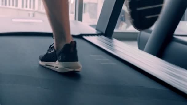 En man i sneakers springer på löpbandet — Stockvideo