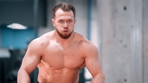 Een jonge man bodybuilder vechten touwen met een inspanning in de sportschool — Stockvideo