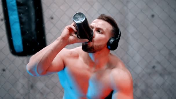 Çekici bir boksör spor salonunda su içiyor. Neon ışıklı. — Stok video