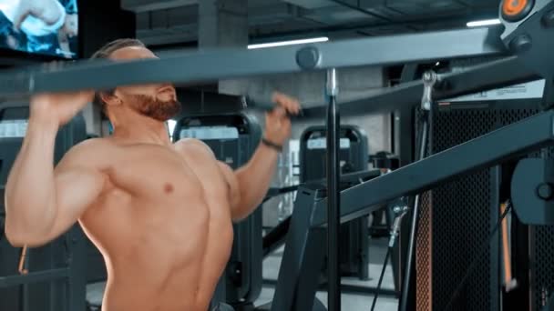 Ένας γενειοφόρος ελκυστικός άνθρωπος bodybuilder κάνει ασκήσεις δύναμης στο αθλητικό γυμναστήριο — Αρχείο Βίντεο