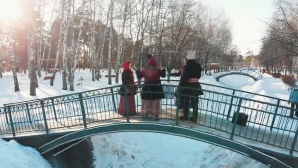 Folklore ruso - la gente en trajes rusos están bailando en el puente — Vídeo de stock