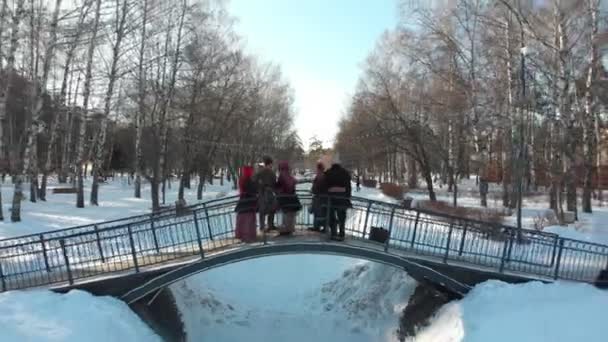 Folklore ruso - la gente en trajes rusos están bailando en el puente en invierno — Vídeos de Stock