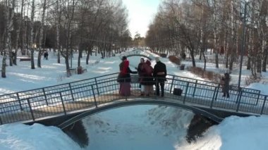 Rus folkloru - Rus kostümlü beş kişi kış parkındaki köprüde dans ediyor.