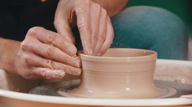 Çömlekçi - sakallı bir adam çömlekçi çarkının arkasında çalışıyor.