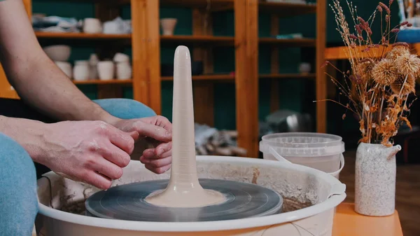 Pottery - potter master is pulling clay in length on a potters wheel with both hands — Stock Photo, Image