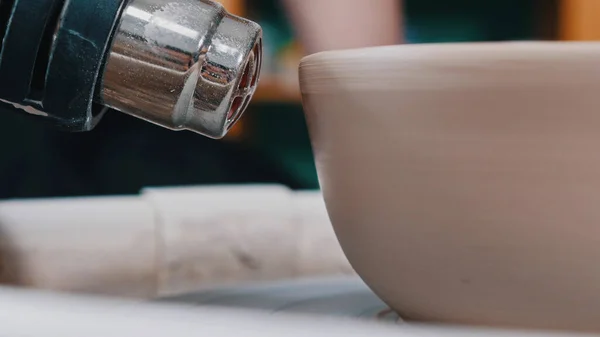 Cerâmica - mestre em está secando uma tigela de argila com um secador de cabelo construção con a roda oleiros — Fotografia de Stock