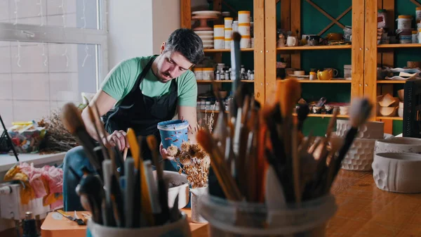 Cerámica - el maestro está sentado en su taller entre sus herramientas —  Fotos de Stock