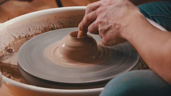 Cerámica - el maestro está presionando el dedo índice en la arcilla en la rueda de alfareros en su taller creativo — Foto de Stock