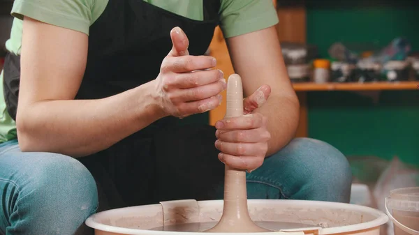 Ceramika - mistrz garncarstwa ciągnie glinę na kole garncarskim obiema rękami — Zdjęcie stockowe