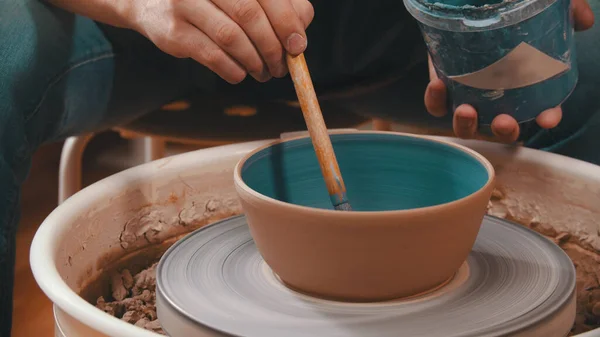Кераміка - майстер сидить у своїй майстерні серед своїх інструментів з блакитним штрихом на гончарному колесі — стокове фото