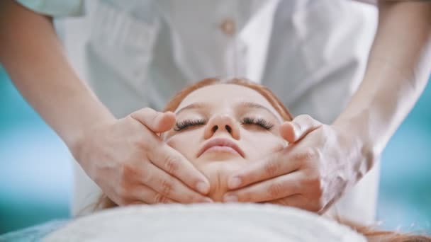 Masaż - masażystka ugniatająca kark młodej kobiecie dłońmi — Wideo stockowe