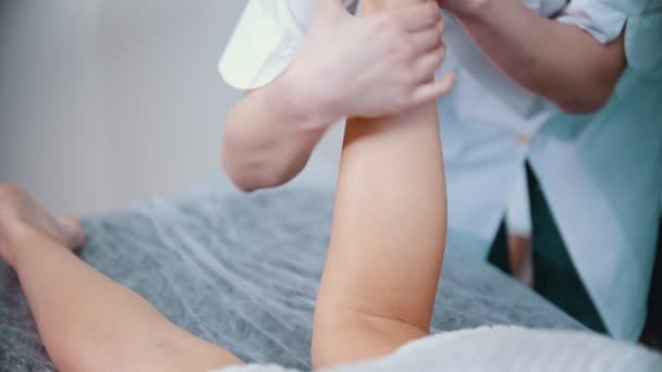 Massage - kvinnlig massage terapeut böja ett ben av en klient massera hennes underben — Stockvideo