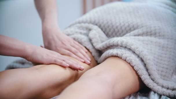 Massage - weibliche Masseurin massiert die Hüften einer schlanken Frau mit einer speziellen Massagetechnik — Stockvideo