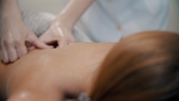 Massagem - mãos femininas massajando as mulheres de volta — Vídeo de Stock