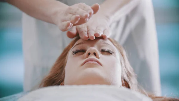 Massaggio - massaggiatrice donna sta impastando i suoi clienti faccia con le palme — Foto Stock