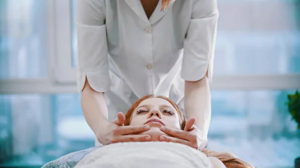 Massaggio - giovane massaggiatrice sta tenendo un massaggio con il suo bel cliente — Foto Stock