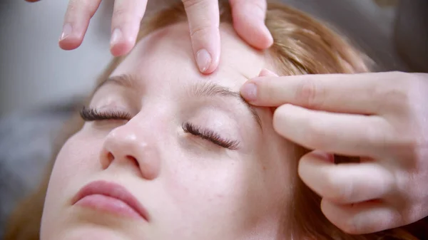 Massaggio - il massaggiatore pizzica il viso di una bella donna — Foto Stock