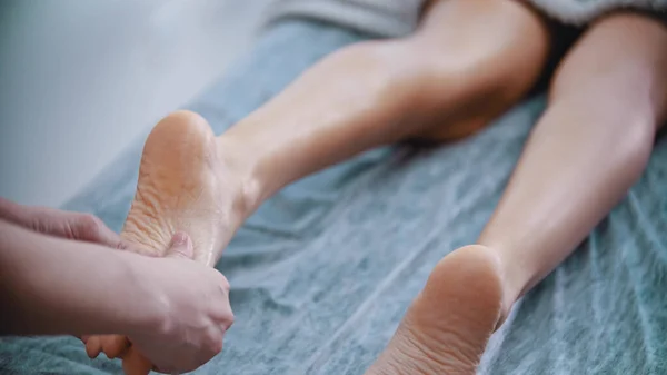 マッサージ – マッサージマスターは女性の足を混練しています — ストック写真