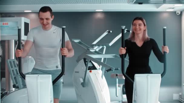 Modernes Fitnessstudio - ein Mann und eine Frau machen Morgengymnastik im Fitnessstudio und reden — Stockvideo