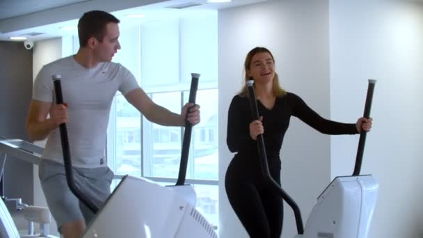 Modern tornaterem - egy férfi és egy nő reggeli gyakorlatokat végez a modern tornateremben — Stock videók