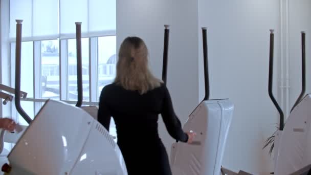 Modern tornaterem - egy férfi és egy nő reggeli gyakorlatokat kezdenek a modern tornateremben — Stock videók