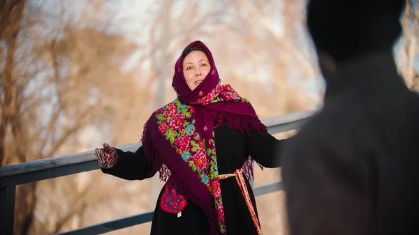 El folklore ruso - la mujer alegre en la bufanda baila en el parque —  Fotos de Stock