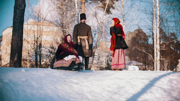 Rus halkı - Rus halk kostümlü kadın ve erkekler kar kaydırağına biniyorlar