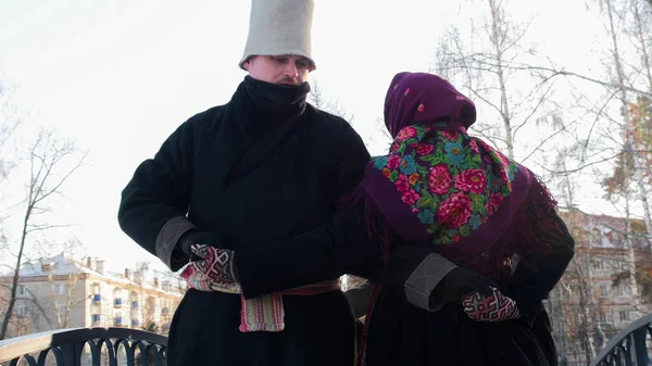Russian folk - man and woman dancing outdoors in traditional russian clothes