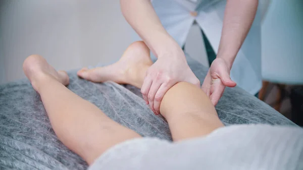 Masszázs - masszázs terapeuta gyúrja a lábát egy fiatal nő — Stock Fotó