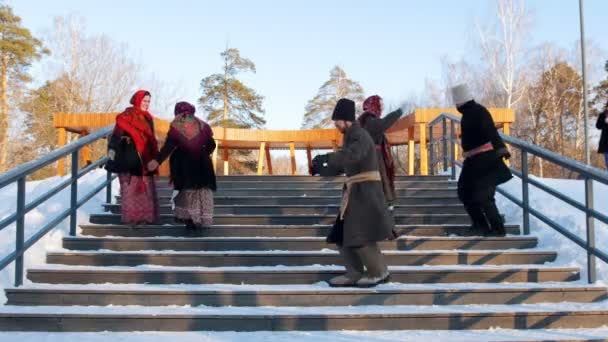 Russische Folklore - Männer und Frauen in Filzstiefeln tanzen auf der Treppe im Winterpark — Stockvideo