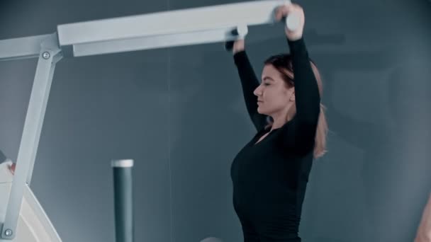Entraînement avec un moniteur de fitness au gymnase - une jeune femme s'entraîne les mains — Video