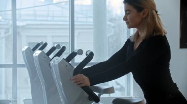 Modern spor salonu - panoramik aynalı beyaz spor salonunda çalışan genç erkek ve kadın.